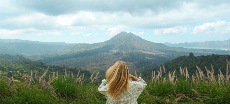 A traveler admires the view of Mount Batur in Kintamani