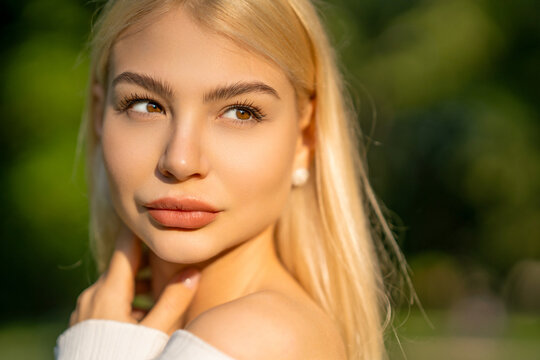 Model with long blonde hair poses gracefully outdoors