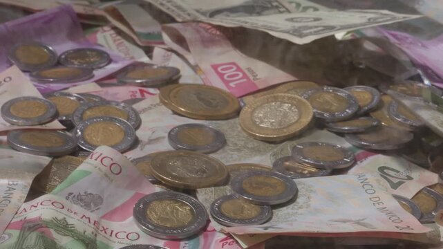 Pile of cash with US paper currency and Mexican coins