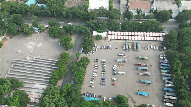 Aerial view of a public bus terminal and parking lot with many buses and cars