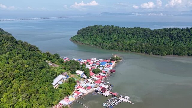 Aerial view captures a small coastal village by a calm sea at Pulau Aman