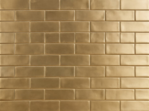 Glossy gold subway tile wall texture with geometric pattern.