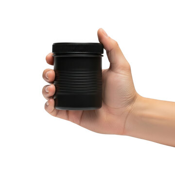 A hand holding a small black round plastic container with a lid isolated on transparent background