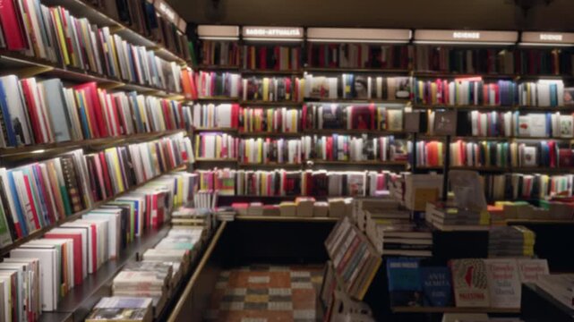 Library bookshelves softly defocused bokeh interior with warm shelf lighting and tiled aisle floor; background backplate copyspace template calm.