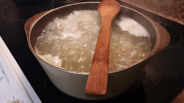 Solomons, Maryland USA Pasta boils in a pot with a wooden spoon to prevent overflow. 