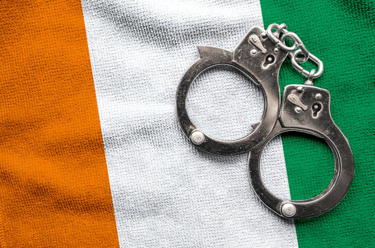 Flag of Ivory Coast and police handcuffs. Crime and offenses in country Concept
