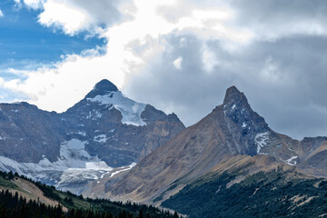 Obraz premium Majestic snow-capped mountains under a dramatic cloudy sky, Glacier Rd, Jasper, Canada