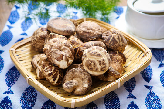 Dried shiitake mushroom on blue printed cloth with teapot