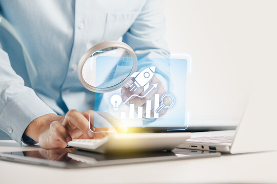 Businessman using magnifying glass and calculator with virtual graphic of growth hacking, rocket launch, and innovative business strategy, concept of startup success and marketing growth.