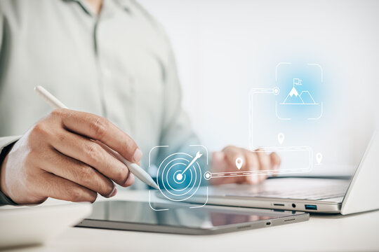 Businessman using stylus pen on digital tablet and laptop with virtual graphic of business goal, roadmap, and mountain peak success, concept of strategy, planning, and corporate vision.