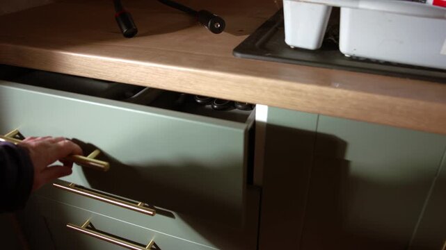 Hand closes kitchen drawer of utensils slow motion medium 4k shot selective focus