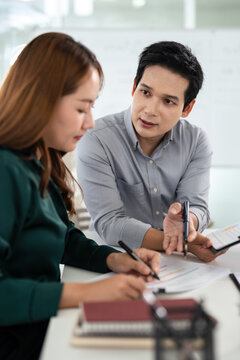 Business partners working with analysis report and advisor showing plan, Two businessman working with Financial analysts reports and planning investment at office.