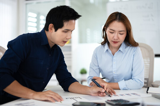 Colleagues in meeting  discussing strategy and insights ,intently reviewing financial data and graphs .