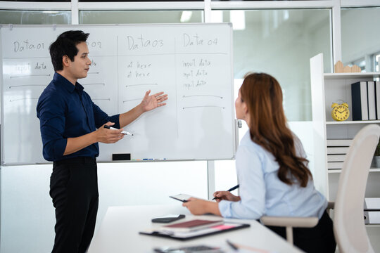 Two professional businesspeople discussing documents , focused collaboration, reviewing financial reports during an office meeting