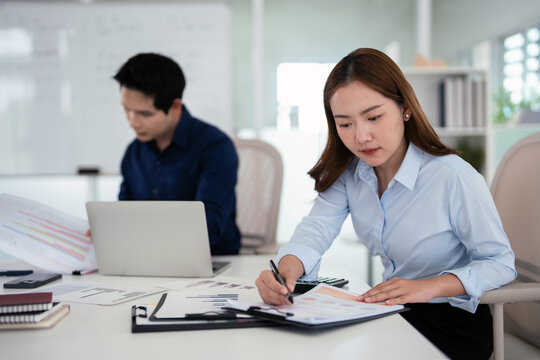 Two businesspeople Analyze financial data and accounting record with calculator in office,