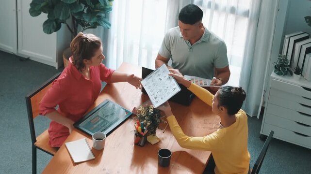 Top down view of project manager present idea while holding tablet at meeting. Skilled business team discussing and planning marketing strategy. Group of interior designer choosing idea. Symposium.