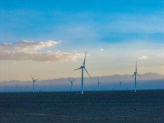 Obraz premium Wind farms at sunset in the Gobi Desert, windmills generating electricity, new energy.