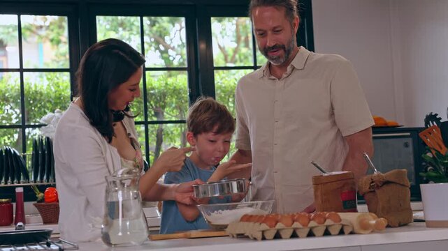 Family Cooking in Bright Kitchen with Mother, Father, and Boy Preparing Fresh Ingredients for Warm Home Meal and Sharing Joyful Parent and Child Food Experience