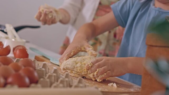 Child baking bread dough in kitchen with adult guidance, hands kneading flour mixture beside fresh eggs, family teamwork and homemade preparation creating warm rustic cooking scene for beginners
