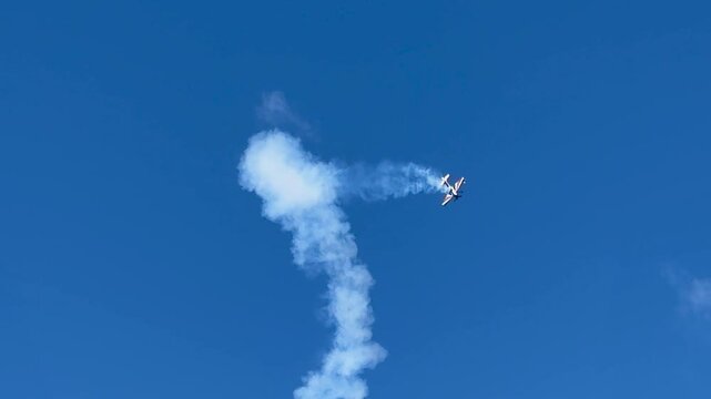 Aerobatic Stunt Plane Performing Maneuvers with Smoke Trails in Gold Coast