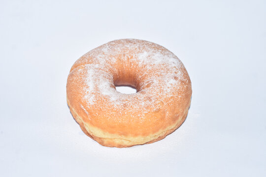 Fresh sweet donut dusted with powdered sugar isolated on white