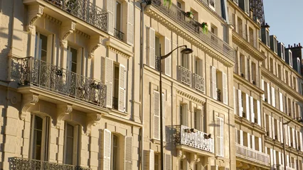 Haussmann style building facade with many balconies and closed shutters under sunlight © 4kclips