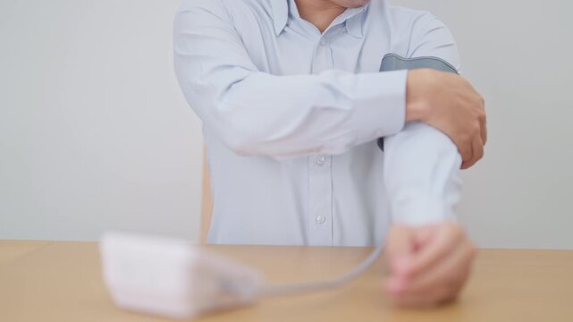 Man checking Blood pressure by Blood pressure monitor with Cuff. Systolic, SYS, Diastolic, DIA, Pulse, Hypertension, Hypotension, Heart rate, Cardiovascular Disease and May World hypertension day