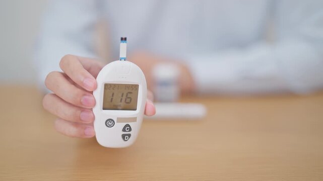 Hand checking Diabetes or Blood glucose self testing by digital blood glucose meter with lancet pen. high blood sugar level, World Diabetes Day, Glycemia, Hypoglycemia, Hyperglycemia and insulin