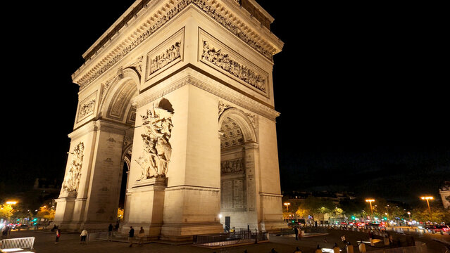 Arc de Triomphe standing brightly illuminated against the dark night sky in Paris