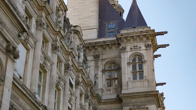 Hotel de Ville facade showing Renaissance Revival architecture, statues, and gargoyles against a blue sky
