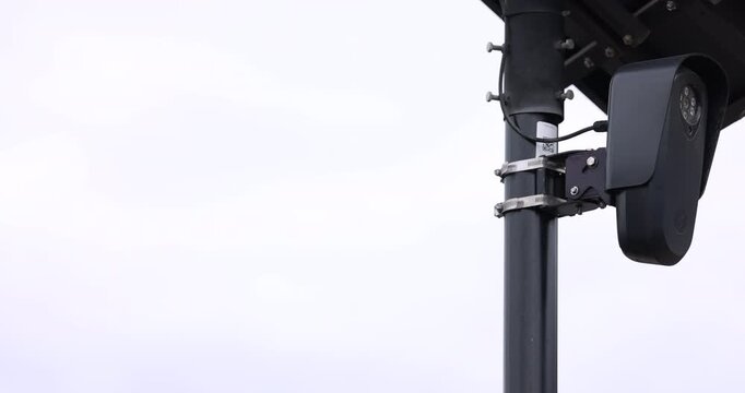 Cloudy daytime view of an AI artificial intelligence camera and solar panel on a pole.