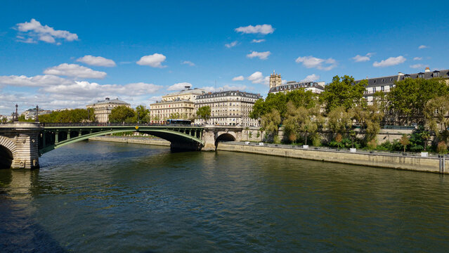 Seine River flowing past Pont Neuf and classic Parisian architecture under a blue sky