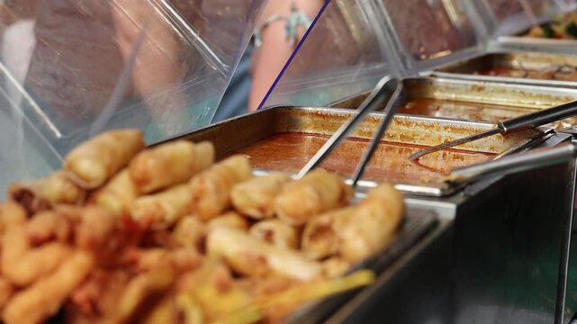 Street food cook preparing the sauce for Asian food in metal outdoor containers
