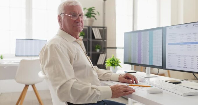 Senior accountant analyst with office spreadsheet data analysis. Experienced finance analyst reviews data on computer ensures accuracy and compliance. Clear trusted financial expertise concept.