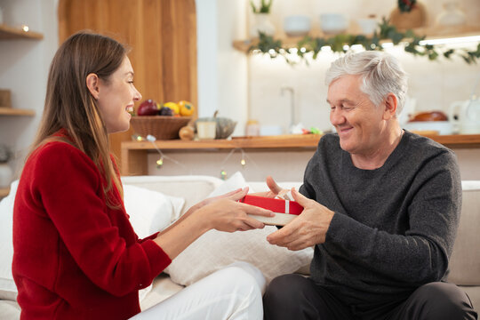 Caucasian woman surprising elderly father with Christmas present