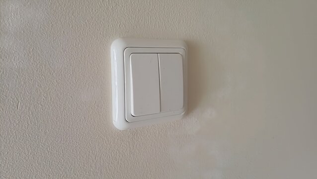 Light switch on wall. White double rocker light switch installed on interior wall. Energy saving, household power control and home renovation concept.