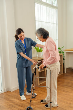 Senior woman nursing home caregiver assistance walker support indoor care therapy gentle caregiver helps senior woman use walker bright nursing home room for mobility support and daily