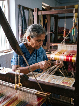 Elderly Indian artisan weaving traditional Uppada silk saree on handloom