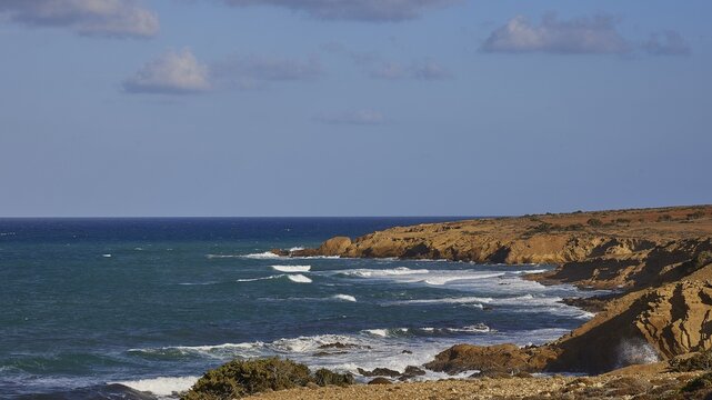 Rocky coast with undulating sea and blue sky in the background, west coast, Karpathos, Dodecanese, Greek Islands, Greece