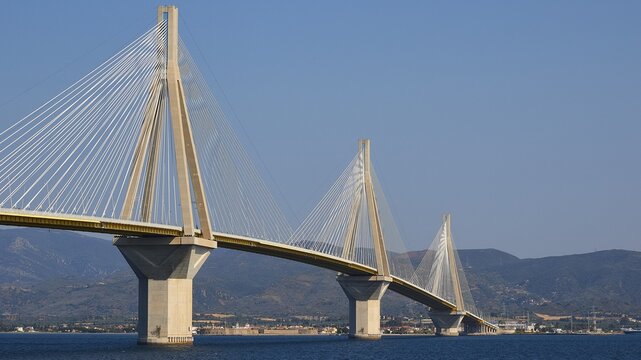 Several bridge pillars with steel cables in front of a mountainous landscape, Rio-Antirrio cable-stayed bridge, Patras, Peloponnese, Greece