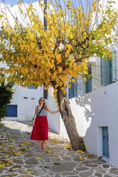 Young woman with red dress in the old town of Lefkes, Paros, Cyclades, Greece