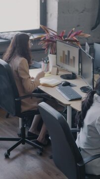 High angle view of busy coworking center with diverse group of people employees working at desks. Office workers and successful business concept.