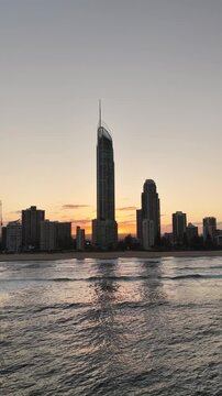 Q1 tower silhouetted against the sunset at Surfers Paradise, aerial drone footage, Gold Coast, Queensland Australia - vertical video