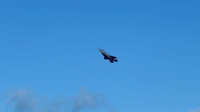 Military Stealth Fighter Jet Flying High in Clear Blue Sky