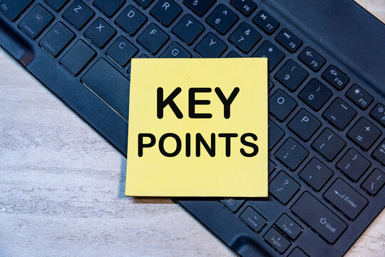 Key points written on yellow sticky note placed on laptop keyboard on wooden office desk background. Concept for summary.