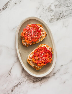 Tuna eggs salad sandwiches with fresh tomatoes on a  light marble background, top view
