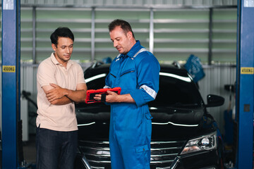 Ev car battery cells service Automotive mechanic explaining car repair to customer inside service...