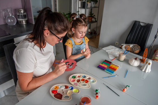 Mother and daughter make Halloween decorations at home