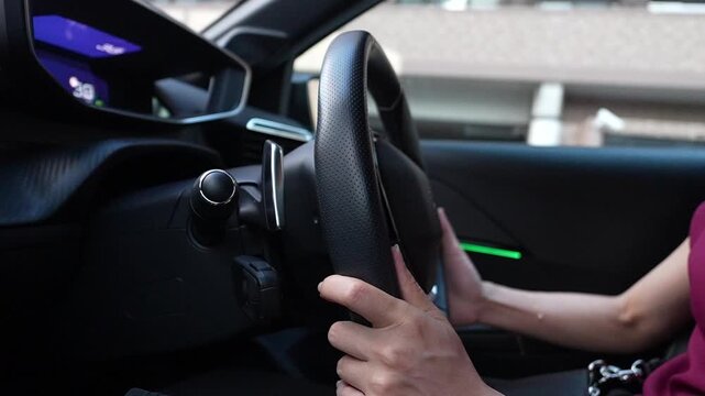自動車のハンドルを握り運転する女性の手元