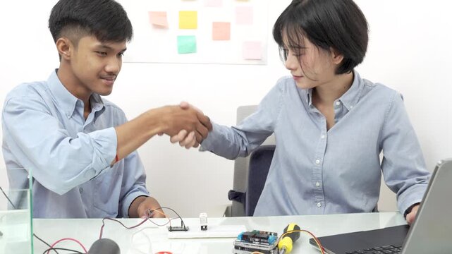 Young Asian woman and man using microcontroller to monitor water quality.